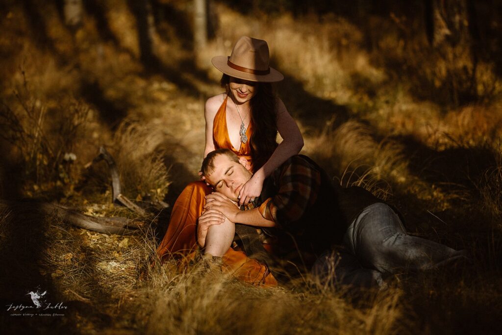 Playful couple dancing through a golden aspen grove during a Colorado fall engagement