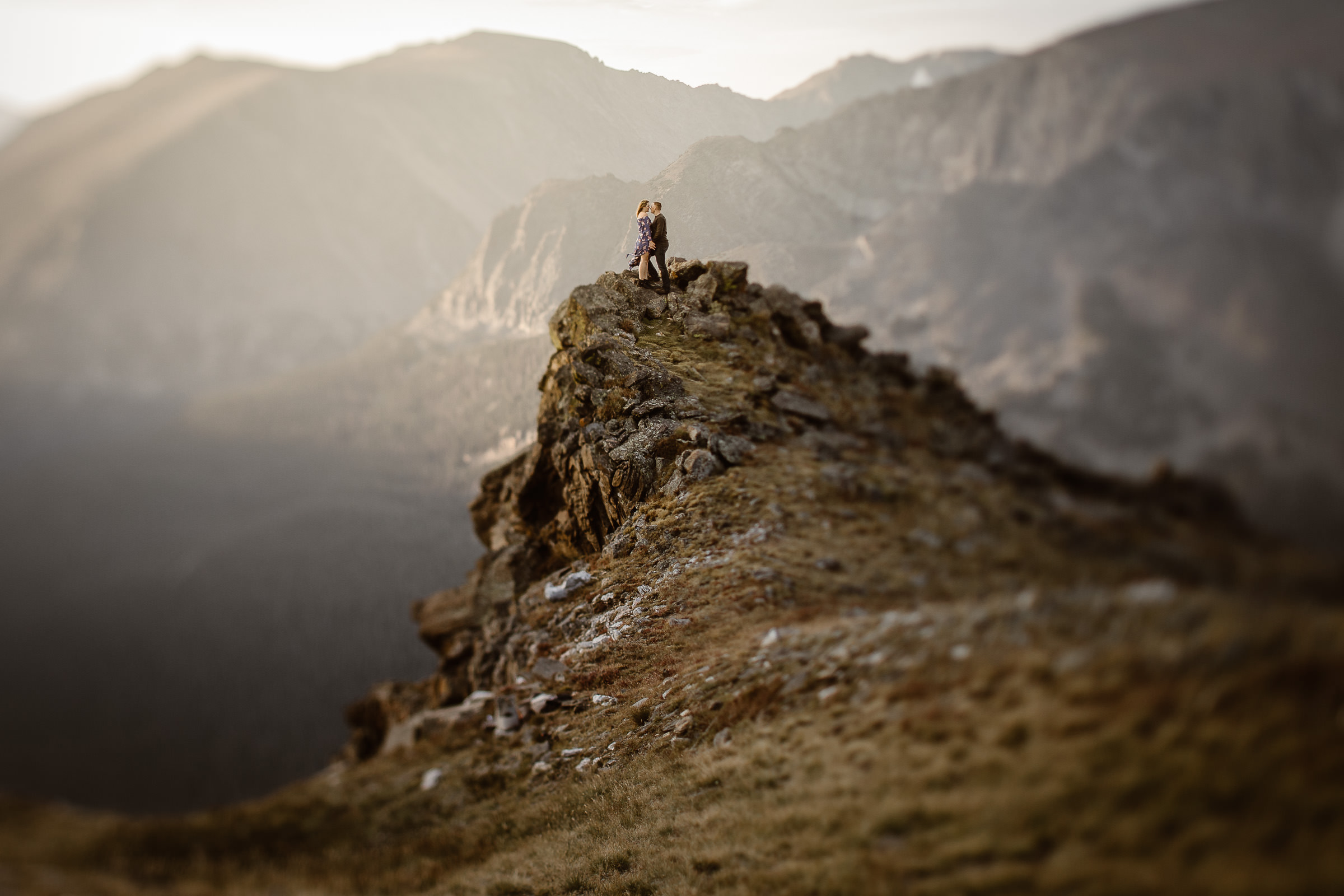 “Romantic Colorado adventure elopement photography capturing a couple standing on a rugged mountain cliff at sunset. This intimate alpine wedding photo highlights the beauty of the Rocky Mountains and the adventurous spirit of the couple.”