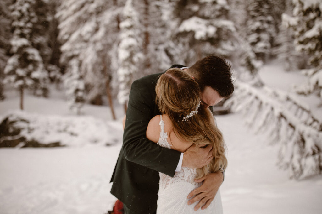 Groom embracing his bride during a winter-like June morning