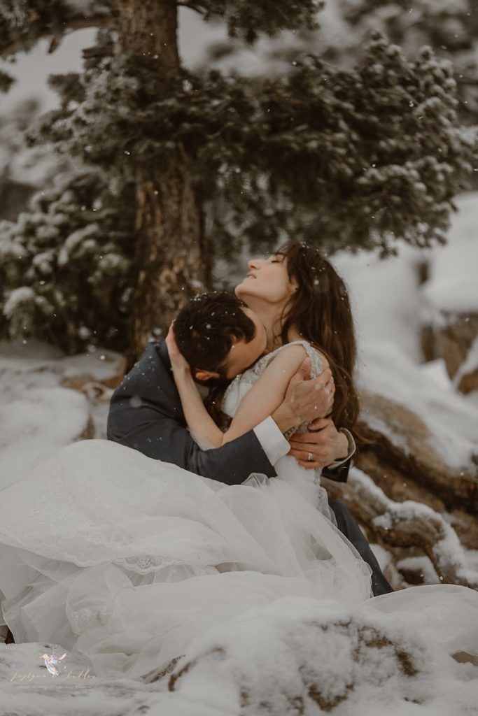 “Emotional Colorado elopement photograph of a bride and groom wrapped in a passionate embrace during a snowy mountain ceremony. Captured by an adventure wedding photographer, this intimate winter elopement highlights romance and alpine beauty.”