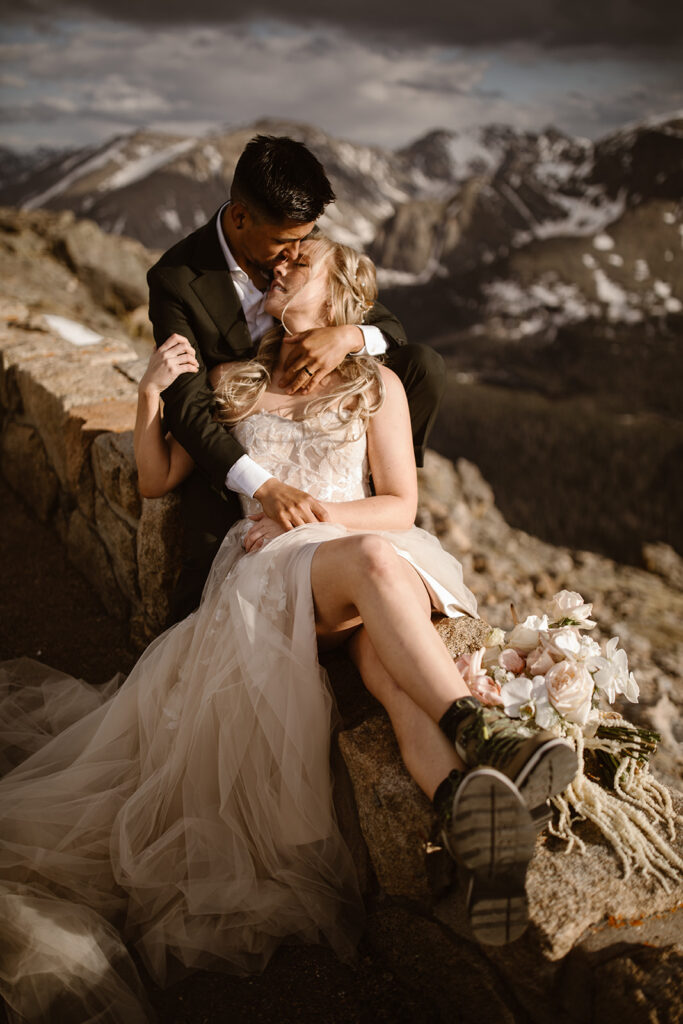 "Romantic and adventurous elopement in Rocky Mountain National Park, Colorado, featuring a couple cuddling at sunset on Trail Ridge Road — photographed by Justyna E Butler, Colorado Elopement Photographer specializing in intimate mountain weddings"