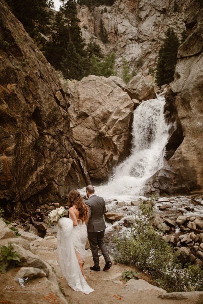 Couple walking through the forest during their Colorado waterfall elopement