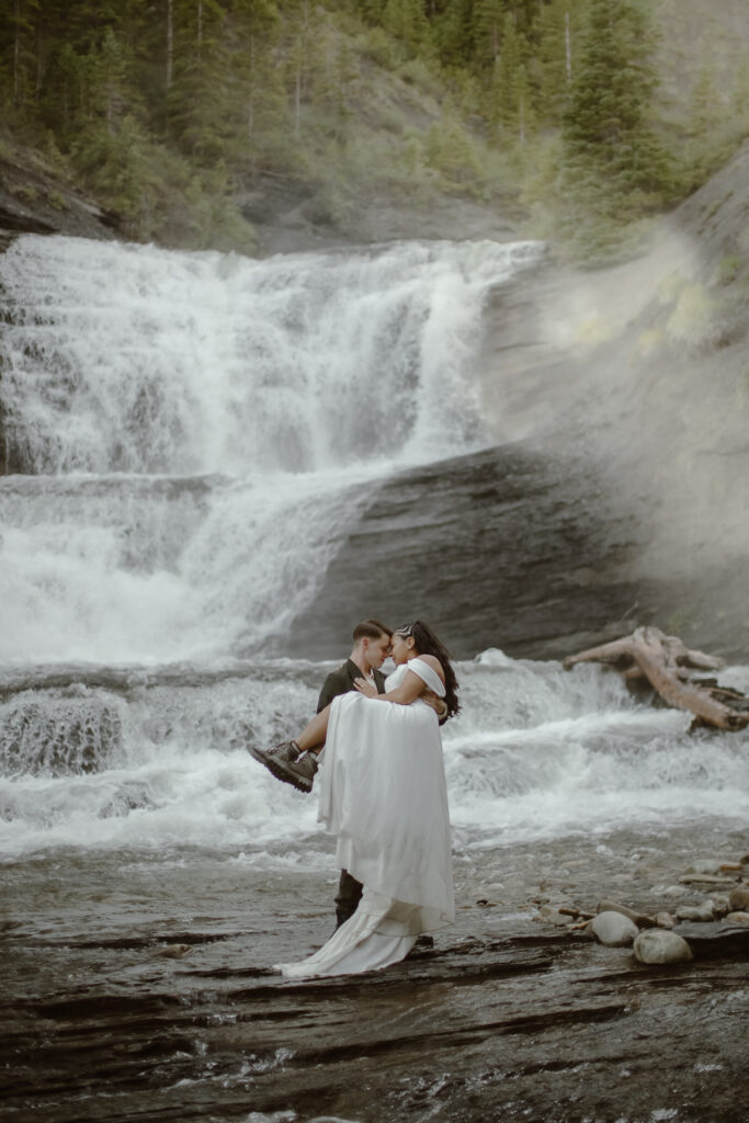 Romantic Colorado waterfall elopement surrounded by lush forest and rushing alpine waters.