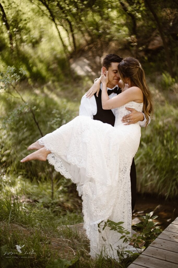 Newlyweds embracing beside Copper Falls during their Colorado waterfall elopement.